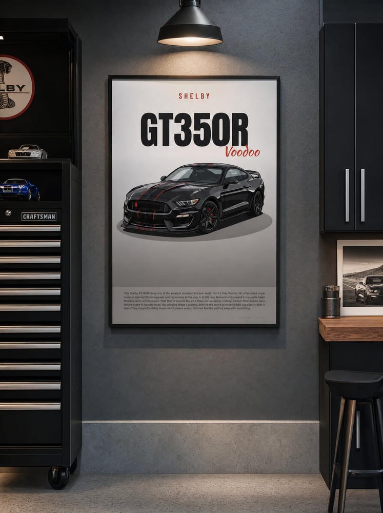 A framed Shelby GT350R poster hanging in a garage